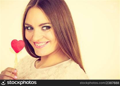 Valentine&rsquo;s day gift concept. Beautiful woman holding love sign, heart shaped wooden hand stick. Beautiful woman holding heart shaped hand stick