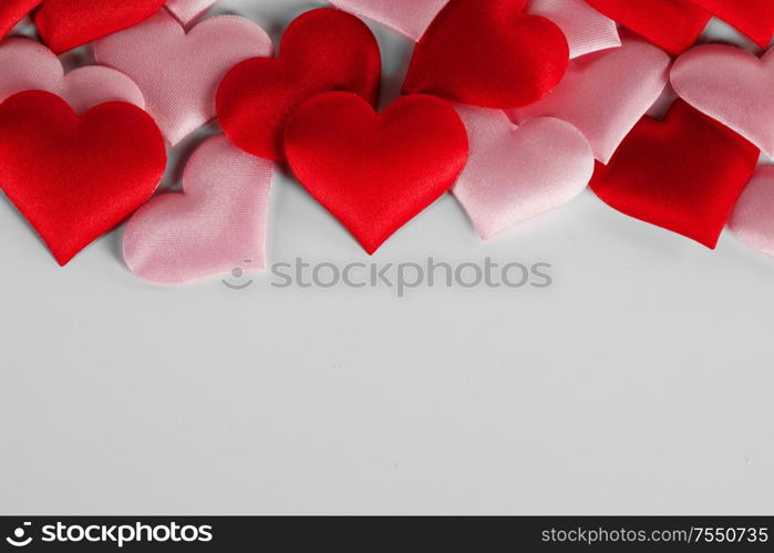 Valentine&rsquo;s day many red and pink silk hearts on white background , border frame with copy space, love concept. Valentines day hearts frame