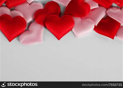 Valentine&rsquo;s day many red and pink silk hearts on white background , border frame with copy space, love concept. Valentines day hearts frame