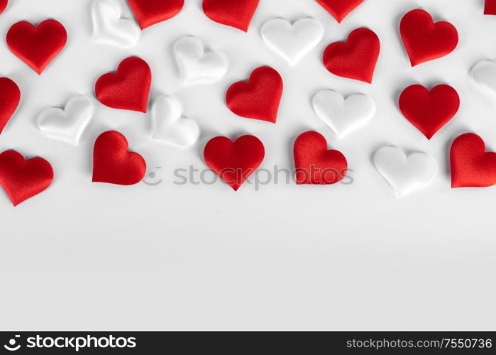 Valentine&rsquo;s day many red and white silk hearts on white background , border frame with copy space, love concept. Valentines day hearts frame
