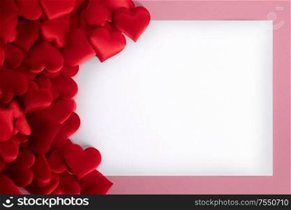 Valentine&rsquo;s day many red silk hearts background , border frame with white card with copy space, love concept. Valentines day hearts frame