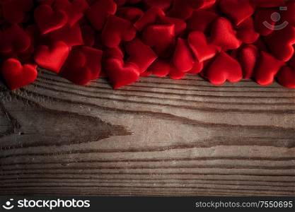 Valentine&rsquo;s day many red silk hearts on wooden background, love concept. Valentines day hearts background