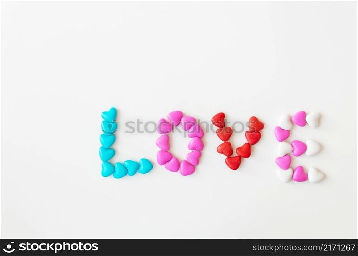 Valentine&rsquo;s day pattern background flat lay top view of bright candies in the shape of the word love scattered on a white background. Valentine&rsquo;s day pattern background flat lay top view of bright candies in the shape of the word love scattered on a white background.