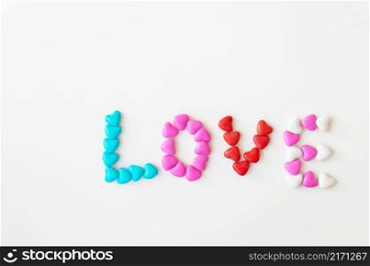 Valentine&rsquo;s day pattern background flat lay top view of bright candies in the shape of the word love scattered on a white background. Valentine&rsquo;s day pattern background flat lay top view of bright candies in the shape of the word love scattered on a white background.