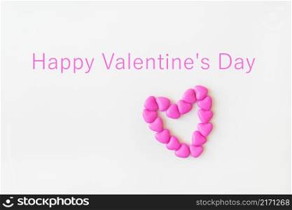 Valentine&rsquo;s day pattern background flat lay top view of heart shaped pink candies scattered on white background. Inscription happy valentine&rsquo;s day. Valentine&rsquo;s day pattern background flat lay top view of heart shaped pink candies scattered on white background. Inscription happy valentine&rsquo;s day.