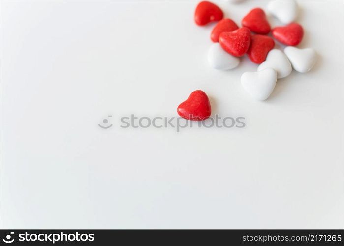 Valentine&rsquo;s day pattern background flat lay top view of red and white heart shaped candies scattered on white background. Place for an inscription. Valentine&rsquo;s day pattern background flat lay top view of red and white heart shaped candies scattered on white background. Place for an inscription.