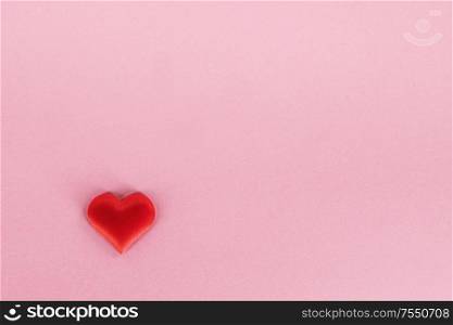 Valentine&rsquo;s day red silk heart on pink paper background, love concept. Valentines day heart on pink