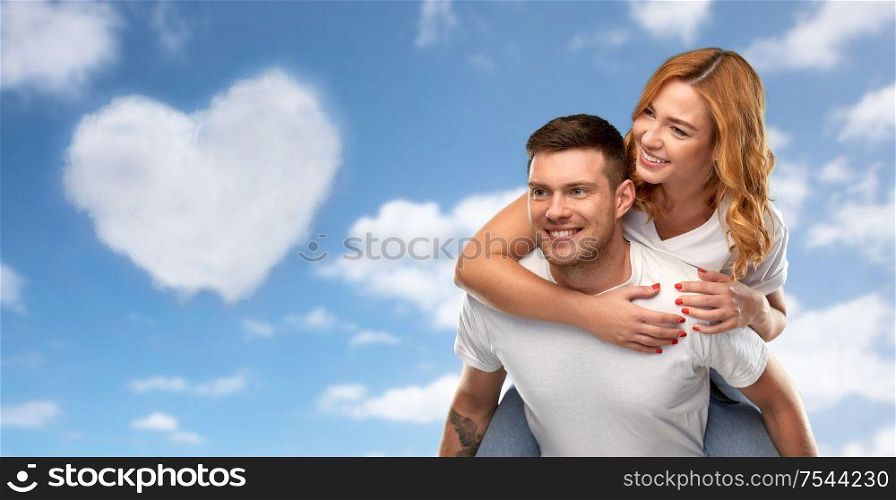 valentine&rsquo;s day, relationships and love concept - portrait of happy couple in white t-shirts having fun over blue sky and cloud in shape of heart background. happy couple in white t-shirts having fun