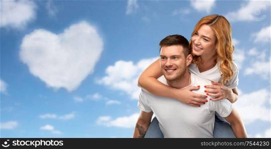 valentine&rsquo;s day, relationships and love concept - portrait of happy couple in white t-shirts having fun over blue sky and cloud in shape of heart background. happy couple in white t-shirts having fun