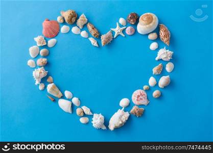 valentine&rsquo;s day, sealife and summer concept - frame of different sea shells in shape of heart on blue background. sea shells in shape of heart on blue background