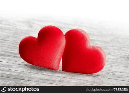 Valentine&rsquo;s day two red silk hearts on wooden background, love concept. Valentines day hearts on wood