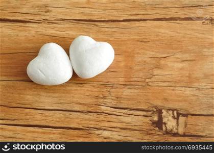 Valentine&rsquo;s Day. Two white polystyrene hearts on a wooden background