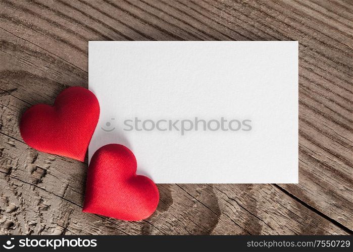 Valentine&rsquo;s day white blank paper greeting card and red silk hearts, background border frame with copy space, love concept. Valentines day card and hearts