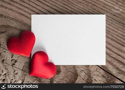 Valentine&rsquo;s day white blank paper greeting card and red silk hearts, background border frame with copy space, love concept. Valentines day card and hearts