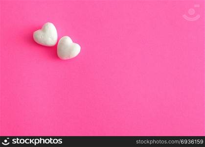 Valentine&rsquo;s Day. White polystyrene hearts on a pink background