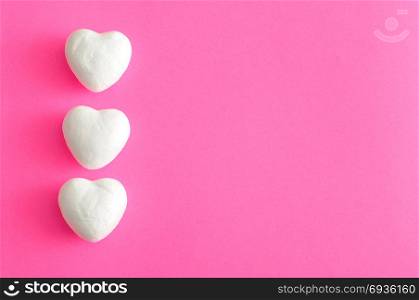 Valentine&rsquo;s Day. White polystyrene hearts on a pink background