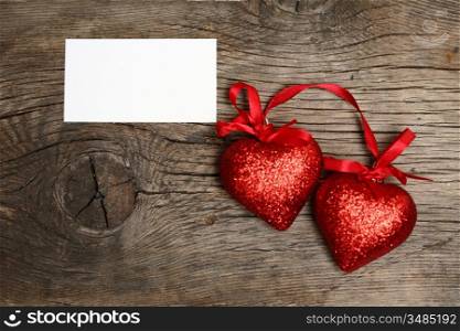 Valentine`s card blank and two hearts on old wood