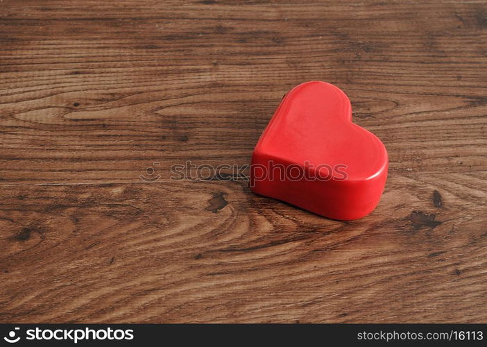 Valentine's day. A red heart isolated on a wooden background