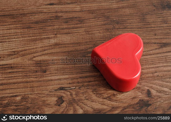 Valentine's day. A red heart isolated on a wooden background