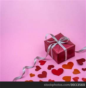 valentine"s day accessory, gift wrapped with gray ribbon, valentine"s day decoration on February 14, pink background. valentine"s day decoration on February 14, gift wrapped with silver ribbon, valentine"s day accessory