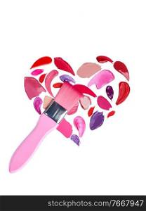 Valentine’s Day background. Red and pink lipstick smeared in the shape of heart. Isolated on white background. Cosmetic brushes
