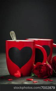 Valentine’s Day concept. Red Cups and roses on a Wooden Background. Love or Valentine’s Day Concept.. Valentine’s Day concept. Red Cups and roses on a Wooden Background
