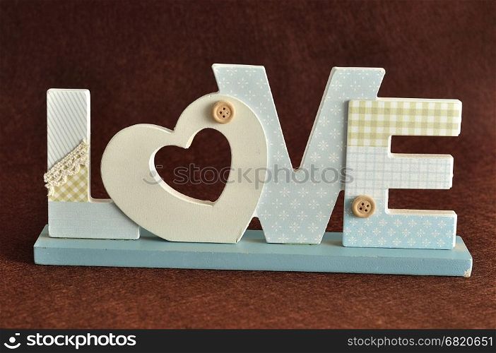 Valentine's Day. Love in blue letters isolated on a brown background