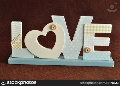Valentine's Day. Love in blue letters isolated on a brown background