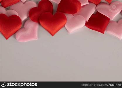 Valentine’s day many red and pink silk hearts on white background , border frame with copy space, love concept. Valentines day hearts frame
