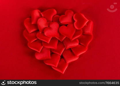 Valentine’s day many red silk hearts on red background, love concept. Valentines day hearts on red