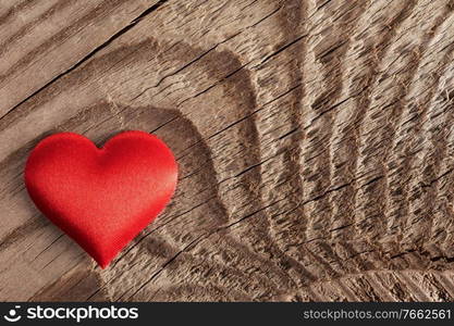 Valentine’s day red silk heart on wooden background, love concept. Valentines day heart on wood