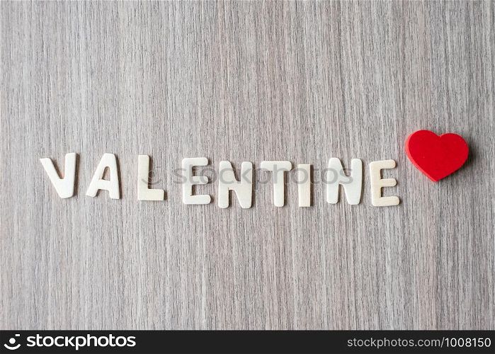 VALENTINE word of wooden alphabet letters with red heart shape on table background. Romance, Romantic and Love concepts