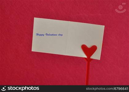 Valentines day. A note holder with a red heart with a note reading hugs and kisses isolated against a pink background
