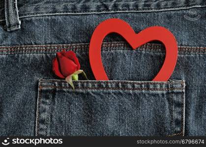 Valentines day. A red rose with a red heart sticking out of a back pocket of a denim jean