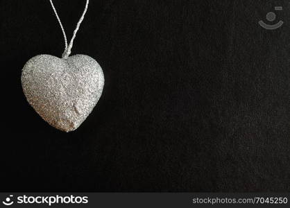 Valentines day. A silver heart isolated against a black background