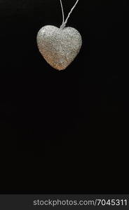 Valentines day. A silver heart isolated against a black background