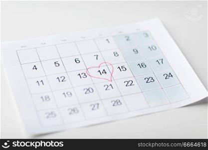 valentines day and holidays concept - close up of calendar sheet with 14th february date marked by red heart shape. close up of 14th february date in calendar