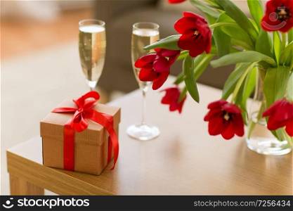 valentines day and romantic concept - gift box, ch&agne glasses and flowers on table. gift box, ch&agne glasses and flowers on table