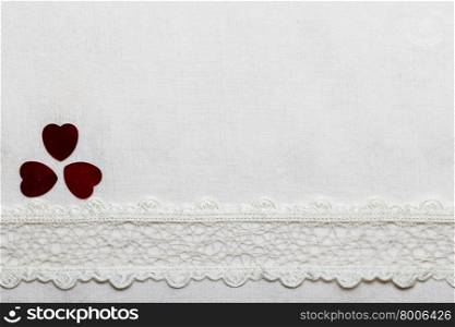 Valentines day background. Lace ribbon and hearts on white cloth. Copy space for text