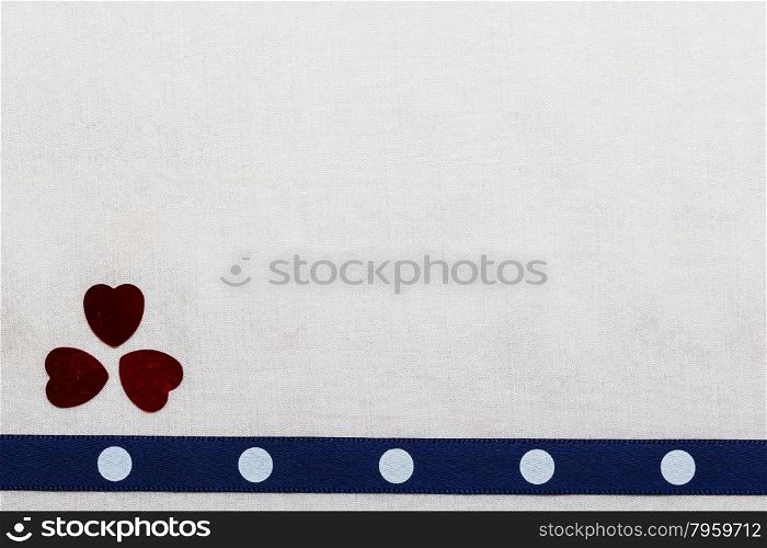 Valentines day background. Navy blue polka dot ribbon and hearts on white cloth. Copy space for text