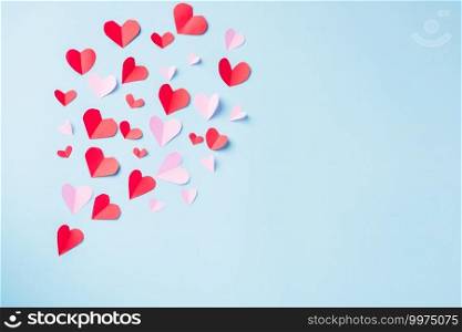 Valentines’ day background. Pattern beautiful red paper hearts cut composition greeting card isolated on blue background with copy space, Symbol of love Top View from above