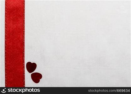 Valentines day background. Red satin ribbon hearts on white cloth. Copy space for text