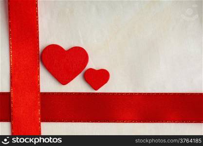 Valentines day background. Red satin ribbon with two wooden hearts on cloth. Copy space for text