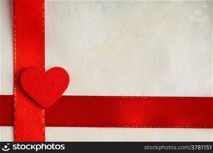 Valentines day background. Red satin ribbon with wooden heart on cloth. Copy space for text