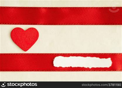 Valentines day background. Red satin ribbon with wooden heart on cloth. Copy space for text