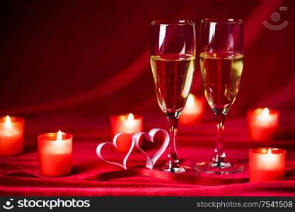 Valentines day background with champagne glasses candles and hearts. Champagne glasses and candles