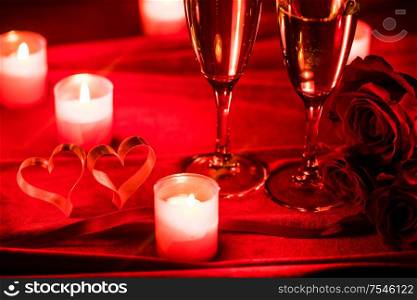 Valentines day background with champagne glasses candles and hearts. Champagne glasses and candles