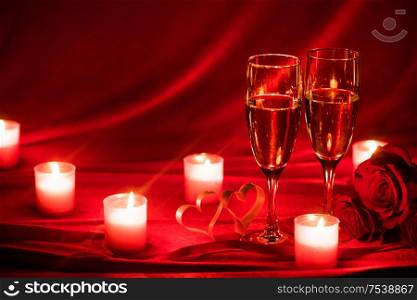 Valentines day background with champagne glasses roses candles and hearts. Champagne glasses and roses