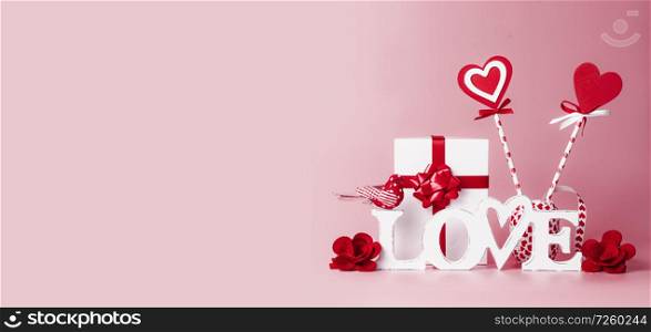 Valentines day background. Word Love, gift box, red ribbons and hearts lollipops. Festive greeting concept. Romantic Love declaration concept. Copy space for your design. Banner.