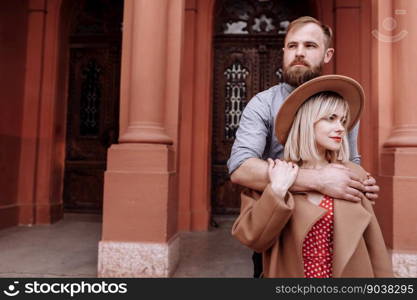 Valentines day. Beautiful stylish happy hipster loving couple is hugging outdoors. Smiling blond woman in hat and bearded man having romantic date at old European city. Concept of love and emotions.. Valentines day. Beautiful stylish happy hipster loving couple is hugging outdoors. Smiling blond woman in hat and bearded man having romantic date at old European city. Concept of love and emotions